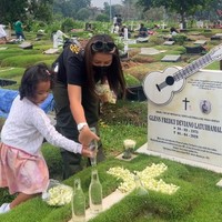 Saat sampai dimakam Glenn Fredly, terlihat Gewa ikut membantu sang ibunda menyiramkan air ke makam. Gewa mengenakan dress warna pink dan cardigan putih. Foto: Instagram @mutia_ayuu