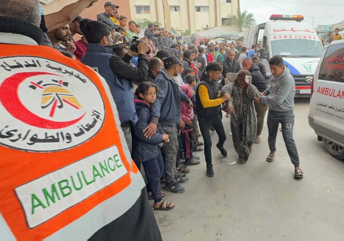 A Palestinian man carries a casualty while rushing into Nasser hospital, amid the ongoing conflict between Israel and Palestinian Islamist group Hamas, in Khan Younis, in the southern Gaza Strip December 15, 2023. REUTERS/Bassam Masoud
