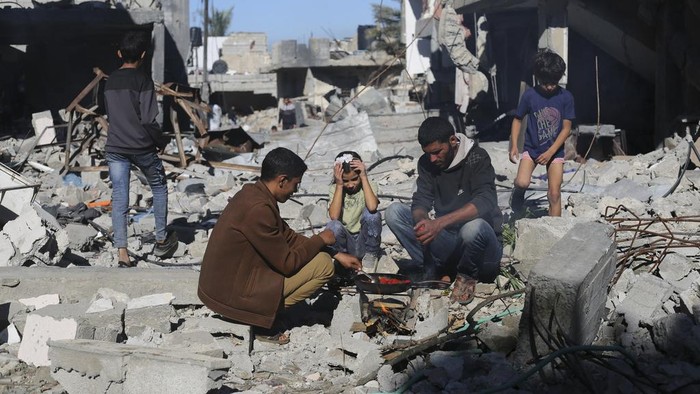 Palestinians cook bread by their destroyed homes in Kuza a Gaza Strip during the temporary ceasefire between Hamas and Israel on Wednesday, Nov. 29, 2023. AP Photo/Hatem Ali)