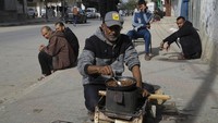 Mereka memasak bahan makanan seadanya untuk bertahan hidup. (AP Photo/Hatem Ali)
