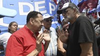 Luis DElía, pemimpin Federasi Tanah, Perumahan dan Habitat, kiri, berbicara dengan pemimpin protes Eduardo Belliboni selama demonstrasi menentang reformasi ekonomi Presiden Javier Milei yang memblokir sebagian Ruta 3 di La Matanza, di pinggiran kota Buenos Aires, Argentina, Kamis (28/12/2023). (AP Photo/Gustavo Garello)  