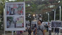 Warga mengamati foto momentum pemberlakukan PPKM.