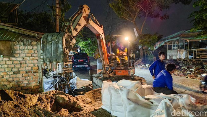 Perbaikan jalan di Gandus Palembang yang rusak akibat air pasang Sungai Musi.