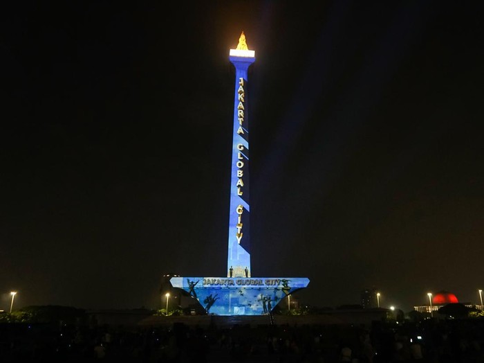Pengunjung menyaksikan pertunjukan video pemetaan Monas Week di Monumen Nasional, Jakarta, Kamis (28/12/2023). Pertunjukan yang akan berlangsung hingga 31 Desember 2023 itu untuk menghibur dan memeriahkan liburan akhir tahun dengan menampilkan tema Natal, liburan sekolah, dan tahun baru. ANTARA FOTO/Rifqi Raihan Firdaus/tom.