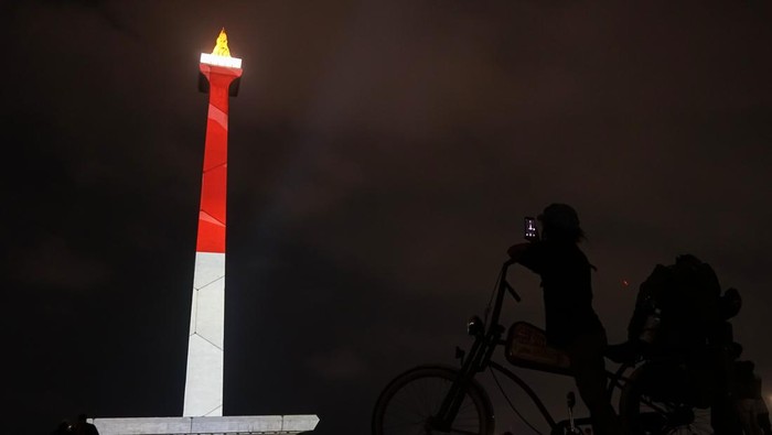 Pengunjung menyaksikan pertunjukan video pemetaan Monas Week di Monumen Nasional, Jakarta, Kamis (28/12/2023). Pertunjukan yang akan berlangsung hingga 31 Desember 2023 itu untuk menghibur dan memeriahkan liburan akhir tahun dengan menampilkan tema Natal, liburan sekolah, dan tahun baru. ANTARA FOTO/Rifqi Raihan Firdaus/tom.