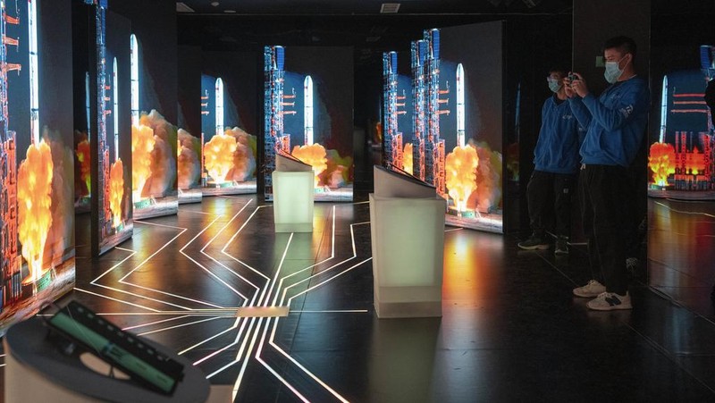 A visitor stands near a display showing earth during an exhibition about China's space program in Beijing, Thursday, Dec. 28, 2023. China's burgeoning space program plans to place astronauts on the moon before 2030 and expand the country's orbiting space station against the background of a rivalry with the U.S. for reaching new milestones in outer space, reflecting their competition for influence on global events. (AP Photo/Ng Han Guan)