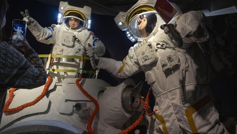 A visitor stands near a display showing earth during an exhibition about China's space program in Beijing, Thursday, Dec. 28, 2023. China's burgeoning space program plans to place astronauts on the moon before 2030 and expand the country's orbiting space station against the background of a rivalry with the U.S. for reaching new milestones in outer space, reflecting their competition for influence on global events. (AP Photo/Ng Han Guan)