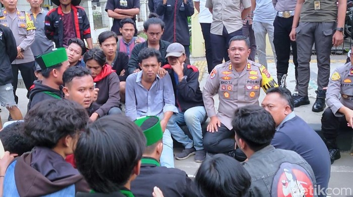 Polisi dan massa mahawasiswa yang aksi depan gedung Wali Kota Cilegon saling damai usai ricuh (M Iqbal/detikcom)