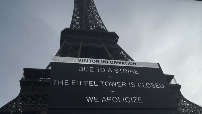 Potret Menara Eiffel Ditutup yang Bikin Wisatawan Kecewa A board warns about a strike at the Eiffel Tower, Wednesday, Dec. 27, 2023 in Paris. The Eiffel Tower was shut down to visitors Wednesday because of a strike over contract negotiations, the day the Paris monument marks 100 years since the death of its creator, Gustave Eiffel. Tourists can still access the glass-enclosed esplanade beneath the tower, but access to the 300-meter (984-foot) landmark itself is closed until further notice, (AP Photo/Lewis Joly)