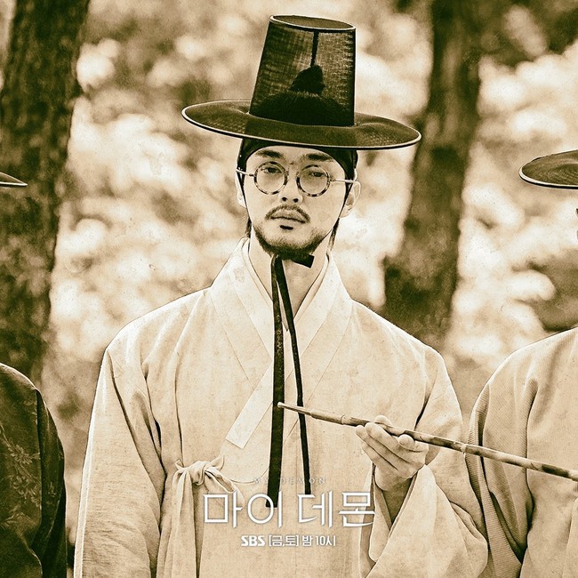 Tak hanya berjanggut, karakter Song Kang juga memakai kacamata di tahun 1895 hingga 1914, dengan nama Jung Sam Won. Sejumlah penggemar menyebut wajahnya mirip Jin BTS hingga Gyuvin ZB1. Foto: dok. SBS