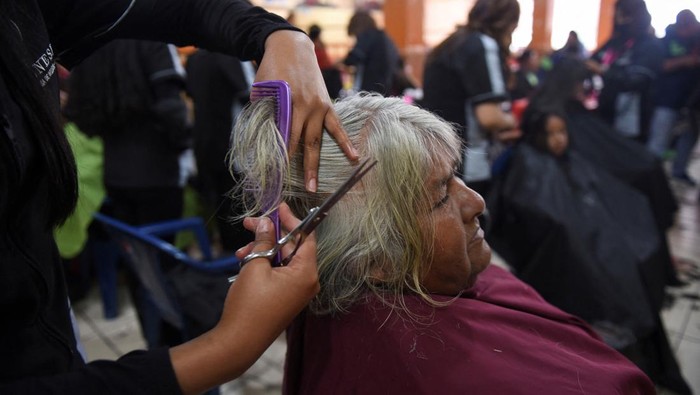 Relawan Gereja di Bolivia Mendandani Ratusan Tunawisma Saat Libur Nataru A volunteer bathes a homeless woman at an evangelical church where homeless people receive clothing, food and free showers during holidays, in La Paz, Bolivia December 28, 2023. REUTERS/Claudia Morales