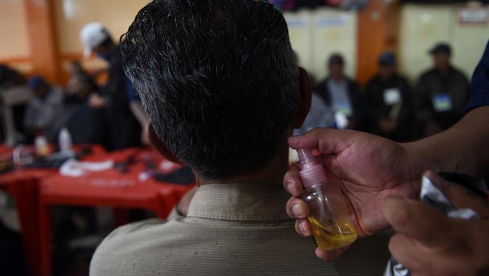 Relawan Gereja di Bolivia Mendandani Ratusan Tunawisma Saat Libur Nataru A volunteer bathes a homeless woman at an evangelical church where homeless people receive clothing, food and free showers during holidays, in La Paz, Bolivia December 28, 2023. REUTERS/Claudia Morales