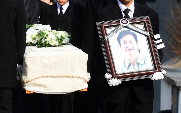 SKOREA-FILM-SUICIDE Mourners carry a portrait and the casket containing late South Korean actor Lee Sun-kyun after his funeral ceremony at the Seoul National University Hospital in Seoul on December 29, 2023. The late South Korean actor Lee Sun-kyun's body was transported from the funeral home to a crematorium in a private ceremony on December 29, with his death raising questions about alleged harsh police practices and media sensationalism. (Photo by KOREA POOL / AFP)