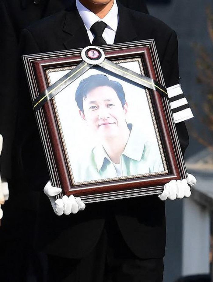 Mourners carry a portrait and the casket containing late South Korean actor Lee Sun-kyun after his funeral ceremony at the Seoul National University Hospital in Seoul on December 29, 2023. The late South Korean actor Lee Sun-kyuns body was transported from the funeral home to a crematorium in a private ceremony on December 29, with his death raising questions about alleged harsh police practices and media sensationalism. (Photo by KOREA POOL / AFP)