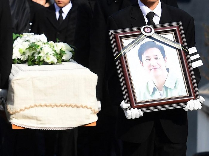 Mourners carry a portrait and the casket containing late South Korean actor Lee Sun-kyun after his funeral ceremony at the Seoul National University Hospital in Seoul on December 29, 2023. The late South Korean actor Lee Sun-kyuns body was transported from the funeral home to a crematorium in a private ceremony on December 29, with his death raising questions about alleged harsh police practices and media sensationalism. (Photo by KOREA POOL / AFP)