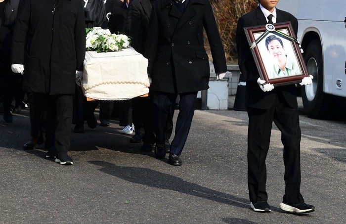 Mourners carry a portrait and the casket containing late South Korean actor Lee Sun-kyun after his funeral ceremony at the Seoul National University Hospital in Seoul on December 29, 2023. The late South Korean actor Lee Sun-kyun's body was transported from the funeral home to a crematorium in a private ceremony on December 29, with his death raising questions about alleged harsh police practices and media sensationalism. (Photo by KOREA POOL / AFP)
