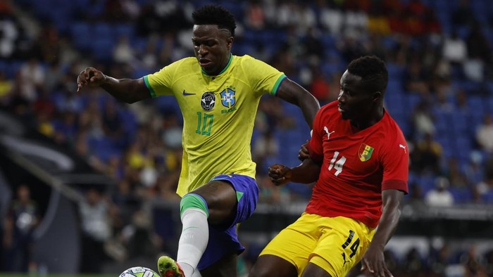 Brazils Vinicius Junior, left, is challenged by Guineas Morlaye Sylla during an international friendly soccer match between Brazil and Guinea at the RCDE Stadium in Barcelona, Spain, Saturday, June 17, 2023. (AP Photo/Joan Monfort)