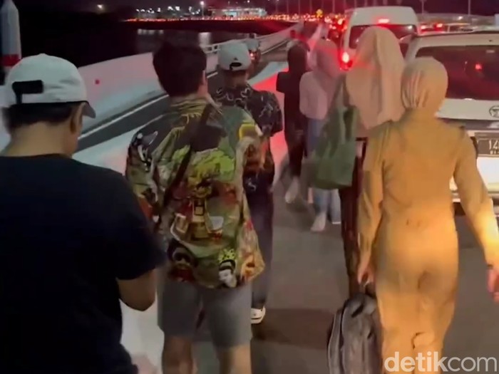 Viral penumpang jalan kaki dan mengangkat koper menuju Bandara Ngurah Rai karena terjebak macet di tol.