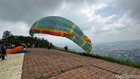 Pilot sedang terbang di lokasi Tandem Paralayang Gunung Banyak, Kota Batu.