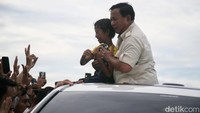 Prabowo juga sempat berfoto dengan seorang anak di atas mobil.