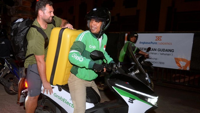 Calon penumpang pesawat berjalan di Jalan Tol Bali Mandara setelah mobil yang ditumpanginya terjebak kemacetan saat akan menuju ke Bandara Internasional I Gusti Ngurah Rai di Badung, Bali, Jumat (29/12/2023). Kemacetan itu terjadi sejak Jumat sore akibat padatnya kendaraan yang melintas di kawasan jalan akses Bandara I Gusti Ngurah Rai pada musim liburan akhir tahun. ANTARA FOTO/Fikri Yusuf/nym.