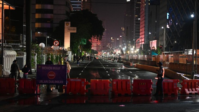 Petugas berjaga di depan Jalan MH. Thamrin yang ditutup dari kendaraan bermotor untuk perayaan pergantian tahun di Jakarta, Minggu (31/12/2023). Sejumlah akses jalan raya menuju Jalan MH Thamrin dan Jalan Sudirman ditutup untuk pelaksanaan car free night menyambut pergantian tahun 2023 ke 2024. ANTARA FOTO/Aditya Pradana Putra/rwa.