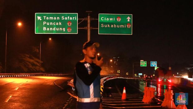 Petugas Jasa Marga sedang melakukan pengalihan arus kendaraan di Simpang Polingga KM 46 Tol Jagorawi, pintu GT Ciawi, Kabupaten Bogor, Jawa Barat, Sabtu (31/12/2022). (CNBC Indonesia/Muhammad Sabki)