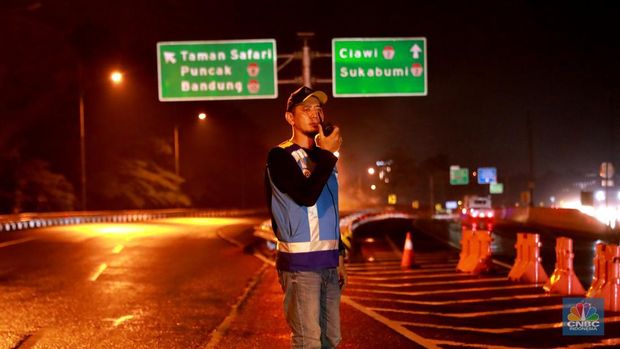 Petugas Jasa Marga sedang melakukan pengalihan arus kendaraan di Simpang Polingga KM 46 Tol Jagorawi, pintu GT Ciawi, Kabupaten Bogor, Jawa Barat, Sabtu (31/12/2022). (CNBC Indonesia/Muhammad Sabki)