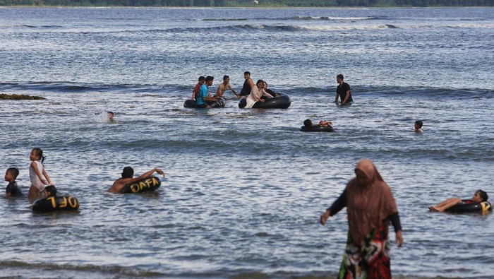 Sejumlah pengunjung berenang di kawasan objek wisata Pantai Desa Lhok Bubon, Kecamatan Samatiga, Aceh Barat, Aceh, Minggu (31/12/2023). Momentum libur sekolah dan libur akhir tahun dimanfaatkan sebagian masyarakat Aceh untuk mengajak keluarganya berlibur ke berbagai tempat rekreasi dan objek wisata seperti wisata pantai, wisata pemandian air terjun dan wahana permainan anak. ANTARA FOTO/Syifa Yulinnas/rwa.