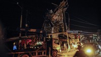 Petugas PLN memperbaiki kabel listrik yang tersangkut rangka atap bangunan setelah diterjang angin puting beliung di Batubantar, Pandeglang, Banten, Sabtu (30/12/2023). 