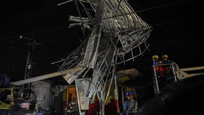 Rangka Atap Rumah di Pandeglang Nyangkut di Tiang Listrik Petugas PLN memperbaiki kabel listrik yang tersangkut rangka atap bangunan setelah diterjang angin puting beliung di Batubantar, Pandeglang, Banten, Sabtu (30/12/2023). BPBD Pandeglang mencatat sebanyak 21 rumah dan enam ruko mengalami kerusakan akibat diterjang angin puting beliung yang terjadi pada pukul 17.00 WIB. ANTARA FOTO/Muhammad Bagus Khoirunas/nym.