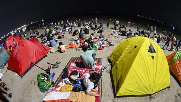 Sambut Tahun Baru, Warga Padati Pantai Ancol hingga Bangun Tenda