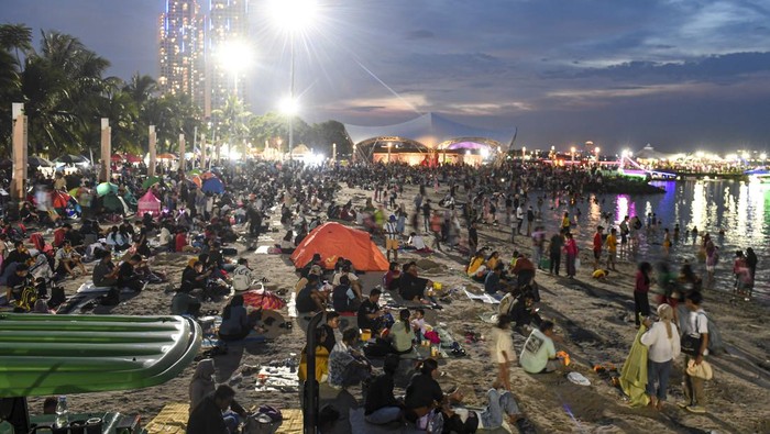 Sambut Tahun Baru, Warga Padati Pantai Ancol hingga Bangun Tenda Sejumlah warga menunggu malam pergantian tahun di Pantai Lagoon, Taman Impian Jaya Ancol, Jakarta, Minggu (31/12/2023). Pantai di Ancol menjadi salah satu destinasi favorit warga Jakarta dan daerah-daerah lainnya untuk menghabiskan malam pergantian tahun dengan hiburan pertunjukan musik dan kembang api. ANTARA FOTO/Muhammad Adimaja/rwa.