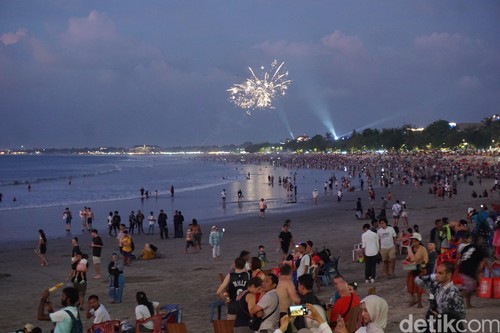 Sejumlah pengunjung Pantai Kuta, Bali menunggu pergantian tahun 2023-2024, Minggu (31/12/2023). (Agus Eka/detikBali)