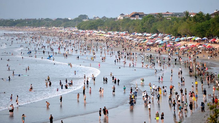 Wisatawan memadati kawasan wisata Pantai Kuta, Badung, Bali, Minggu (31/12/2023). Pantai Kuta dipadati oleh ribuan wisatawan dari berbagai negara untuk berlibur pada akhir tahun 2023. ANTARA FOTO/Fikri Yusuf/rwa.