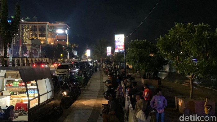 Warga padati pinggir pantai depan kantor Gubernur Papua di malam tahun baru 2024. Raymond/detikSulsel