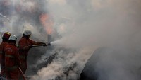 Sejumlah petugas Dinas Pemadam Kebakaran dan Penyelamatan Kota Surabaya berusaha memadamkan api yang membakar gudang palet tersebut.  