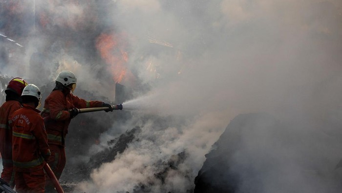 Warga menyelamatkan barang miliknya saat terjadi kebakaran gudang palet di Jalan Jepara, Surabaya, Jawa Timur, Senin (1/1/2024). Dinas Pemadam Kebakaran dan Penyelamatan Kota Surabaya mengerahkan 25 unit mobil  pemadam kebakaran untuk memadamkan api yang meludeskan 12 petak bangunan tempat penyimpan palet kayu, palet plastik dan tempat pengepulan barang bekas. ANTARA FOTO/Didik Suhartono/Spt.