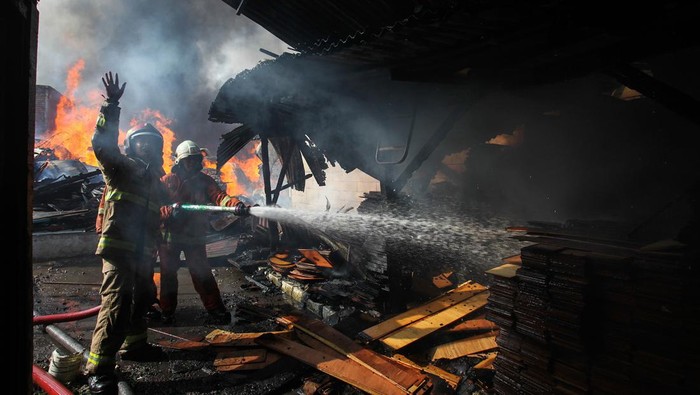 Kebakaran gudang palet di Surabaya Warga menyelamatkan barang miliknya saat terjadi kebakaran gudang palet di Jalan Jepara, Surabaya, Jawa Timur, Senin (1/1/2024). Dinas Pemadam Kebakaran dan Penyelamatan Kota Surabaya mengerahkan 25 unit mobil pemadam kebakaran untuk memadamkan api yang meludeskan 12 petak bangunan tempat penyimpan palet kayu, palet plastik dan tempat pengepulan barang bekas. ANTARA FOTO/Didik Suhartono/Spt.