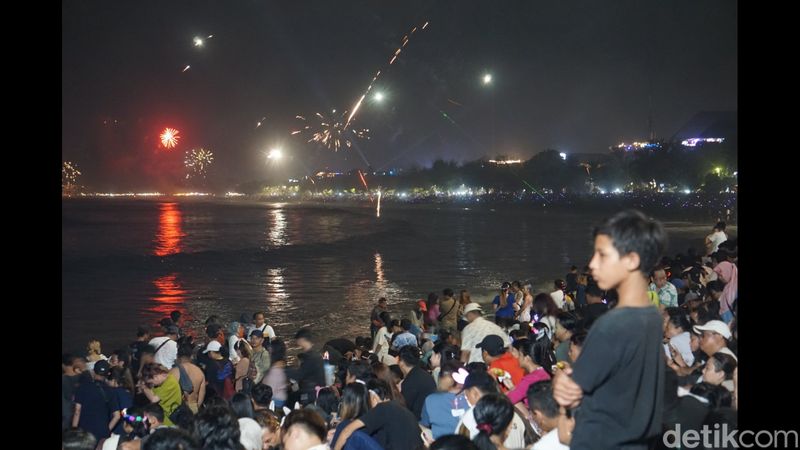 Pantai Kuta, Bali bak lautan. Pengunjung penuh sesak saksikan 2.024 kembang api, Senin (1/1/2023). (Agus Eka/detikBali)