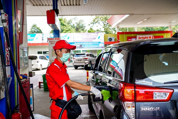 Petugas di SPBU sedang mengisi BBM ke mobil pelangan di Palembang saat libur Nataru.