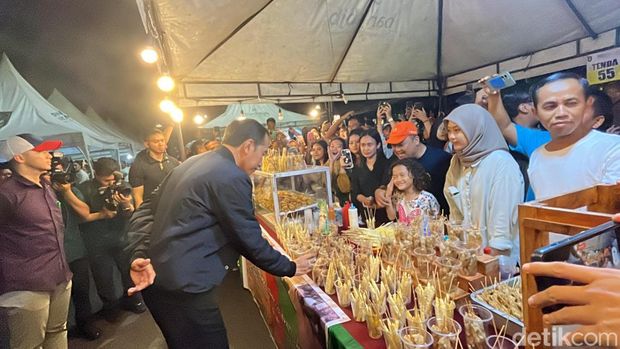 Presiden Joko Widodo (Jokowi) membeli telur gulung saat kunjungan di Solo Car Free Night, Minggu (31/12/2023).