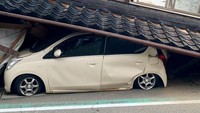 Gempa mengakibatkan rumah ambruk menimpa mobil di Shika, Prefektur Ishikawa. Kyodo via Reuters.