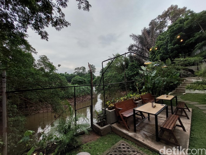 Pengunjung sedang menikmati kafe aesthetic di tepi sungai