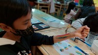 Kegiatan melukis tubuh atau body painting di Crayon Factory