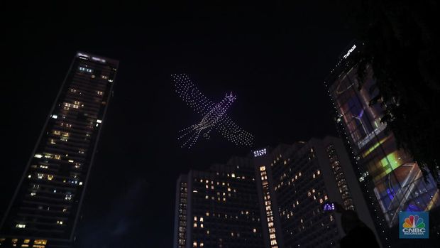 Warga menyaksikan atraksi drone saat Car Free Night (CFN) perayaan malam Tahun Baru 2024 di kawasan Bundaran Hotel Indonesia (HI), Jakarta, Minggu (31/12/2023). (CNBC Indonesia/Faisal Rahman)