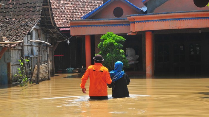 Anggota Taruna Siaga Bencana (Tagana) membantu seorang warga yang terdampak banjir di Desa Ngambakrejo, Tanggungharjo, Grobogan, Jawa Tengah, Selasa (2/1/2024). Menurut data sementara BPBD setempat, banjir akibat hujan deras dan meluapnya Sungai Tuntang itu menyebabkan ratusan rumah dan fasilitas umum serta sejumlah jalan utama di tujuh desa di lima kecamatan terdampak banjir. ANTARA FOTO/Yusuf Nugroho/tom.