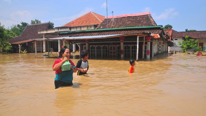 Anggota Taruna Siaga Bencana (Tagana) membantu seorang warga yang terdampak banjir di Desa Ngambakrejo, Tanggungharjo, Grobogan, Jawa Tengah, Selasa (2/1/2024). Menurut data sementara BPBD setempat, banjir akibat hujan deras dan meluapnya Sungai Tuntang itu menyebabkan ratusan rumah dan fasilitas umum serta sejumlah jalan utama di tujuh desa di lima kecamatan terdampak banjir. ANTARA FOTO/Yusuf Nugroho/tom.