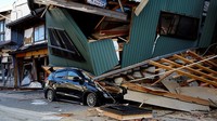 Sebuah mobil tertimpa bangunan rumah di Nanao, Prefektur Ishikawa, Jepang, Selasa (2/1/2024). Reuters/Kim Kyung-Hoon.