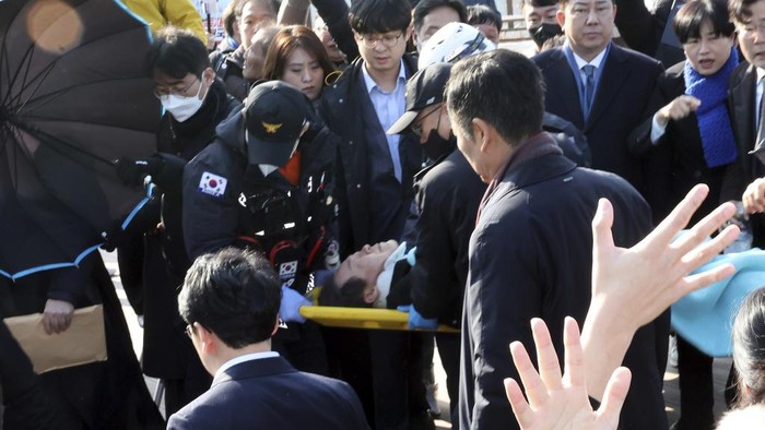 South Korean opposition leader Lee Jae-myung on a stretcher, is carried by rescue team in Busan, South Korea, Tuesday, Jan. 2, 2024. Lee was attacked and injured by an unidentified man during a visit Tuesday to the southeastern city of Busan, emergency officials said. (Ha Kyung-min/Newsis via AP)